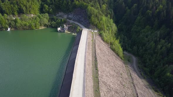 Aerial take off shot of Road diving water and land where reservoir is