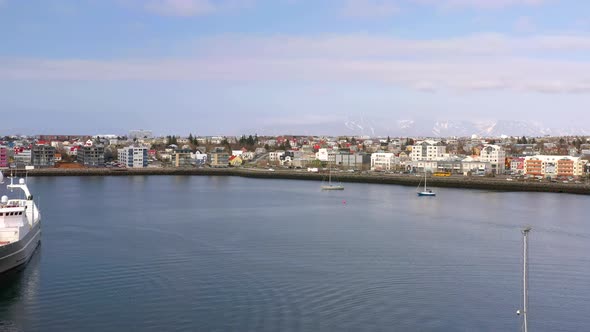 Flying Over The Sea From The Port Towards Waterfront Residential Houses And Buildings. - aerial forw