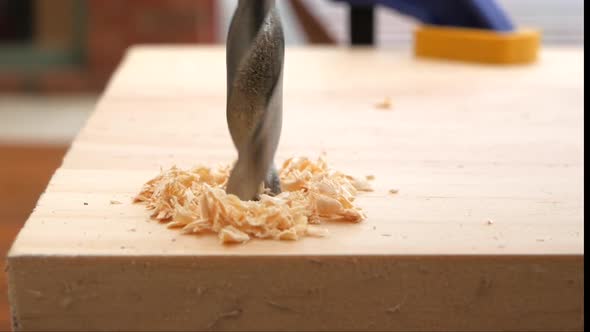 Drilling a hole into a piece of timber using a metal drill bit. SLOW MOTION