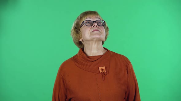Portrait of Senior Woman Is Waiting Isolated Over Green Background.