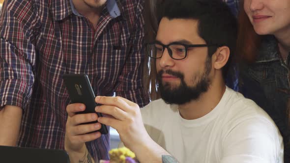 Group of Friends Using Smart Phone Together at the Coffee Shop