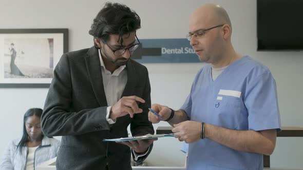 Dentist helping to fill out questionnaire with patient