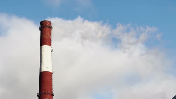 Steam From Pipes of a Thermal Power Plant Over Winter the City Blue Sky and Sun