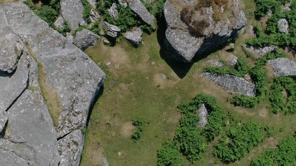 Tracking and rotating aerial of a rocky tor in the heart of dartmoor, England