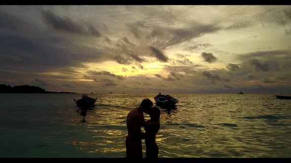 Boy and girl relax on exotic tourist beach lifestyle by blue lagoon and clean sand background of the