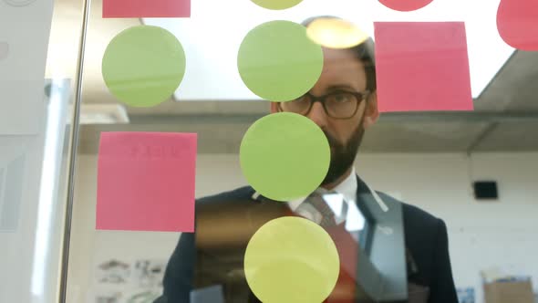 Businessman writing on sticky note