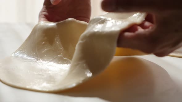 Streching dough for fine shaping baked goods 4K 2160p 30fps UltraHD video - Bread or pizza dough spr