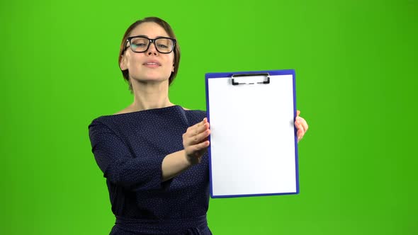 Woman Raises a Paper Tablet and Smiles. Green Screen