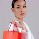 Beautiful Asian modern look businesswoman holding red shopping bag and looking at camera - VideoHive Item for Sale