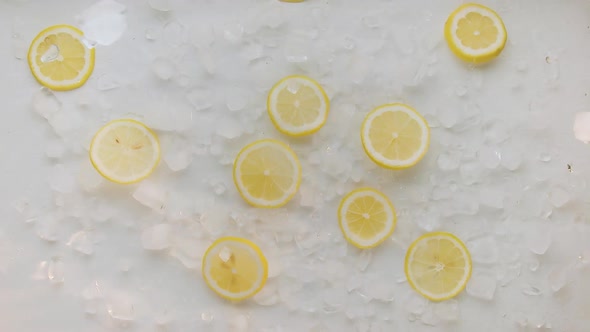 Lemon Slice Jump and Fall with Ice Cube on White Background