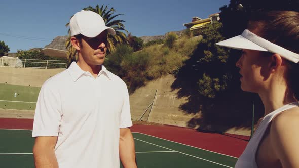 Woman and man playing tennis on a sunny day