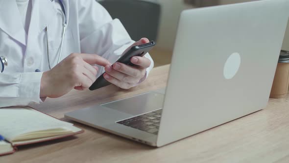 Man Doctor Use Mobile Phone During Work On Laptop Computer