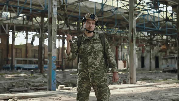 Soldier From US Army Posing on Destroyed Plant with Gun