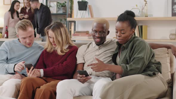 Young People Using Mobile Phones at Get-Together