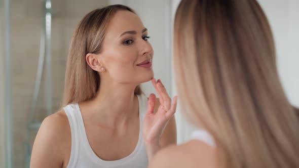 Young woman looking at herself in the mirror in the morning. Shot with RED helium camera in 8K.