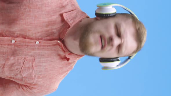 Young Man Air Wearing Headphones and Playing Air Guitar