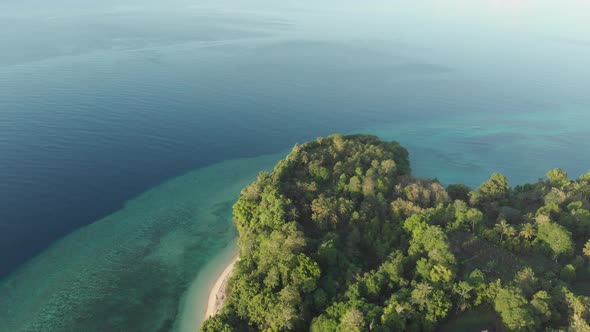 Aerial: flying over tropical Ai island white sand beach Banda Islands Maluku Ind