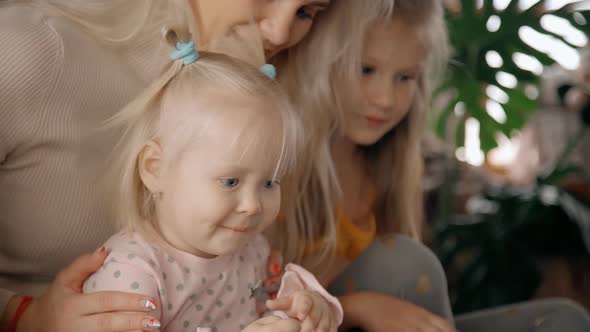 Mother and Two Daughters Watching Cartoon Together.