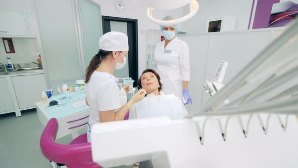 Female Patient is Talking to Dentists While Being in a Chair