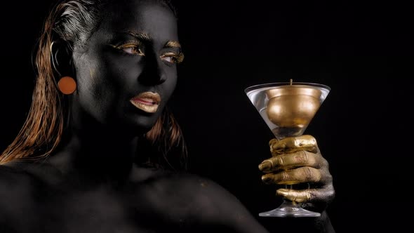 Closeup of a Young Woman with Black and Gold Paint on Her Body