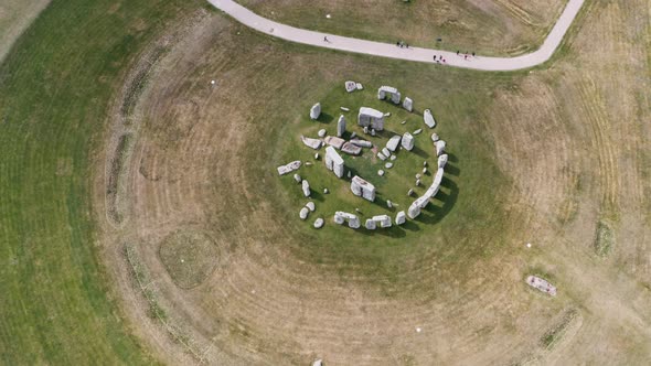 dolly back pan up top down drone shot of Stonehenge UK