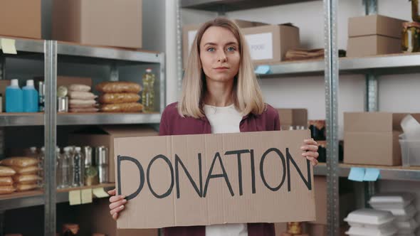 Young Woman Holding Banner with Text Donation at Storage