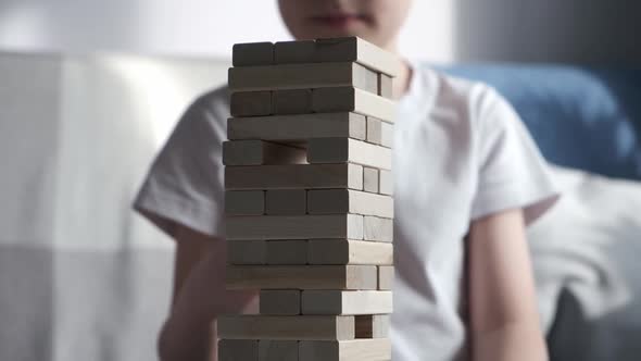 Mother and Son is Playing in Board Game with Wooden Tower Together at Home