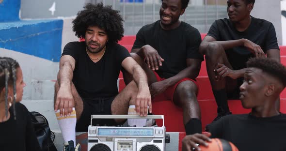 Group of young multiracial people listening music from vintage boombox stereo in the city