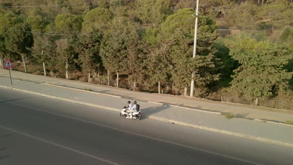 The Drone Follows a Motorcycle That Travels Along the Road Along the Sea Coast