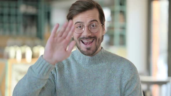 Portrait of Young Man Waving Welcoming