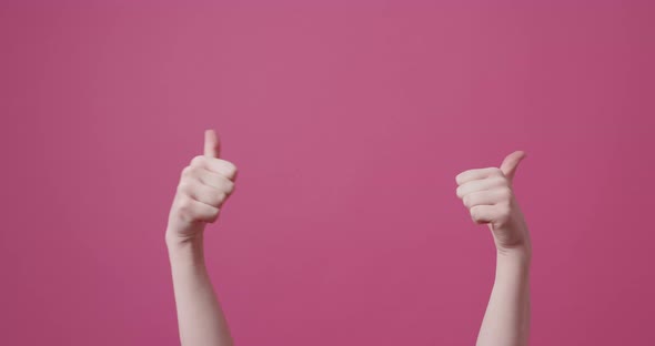 The Young Woman Shows the Like Symbol on an Isolated Pink Background