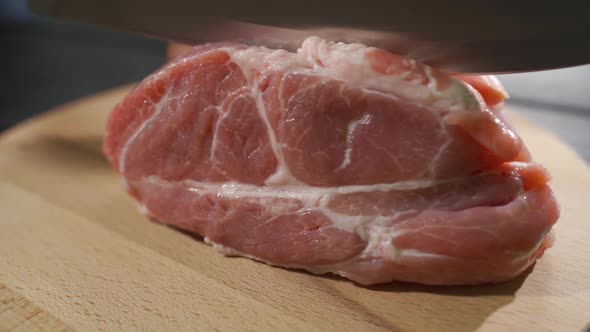 The Chef Cuts Raw Meat with the Knife in Slow Motion