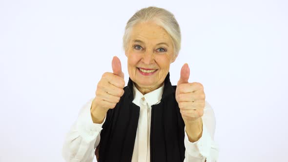 An Elderly Woman Smiles and Shows a Thumb up To the Camera - White Screen Studio