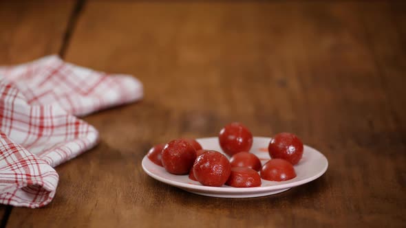 A Pastry Chef in Rubber Gloves Makes Strawberry Balls. Making Jelly Toppings for the Cake.