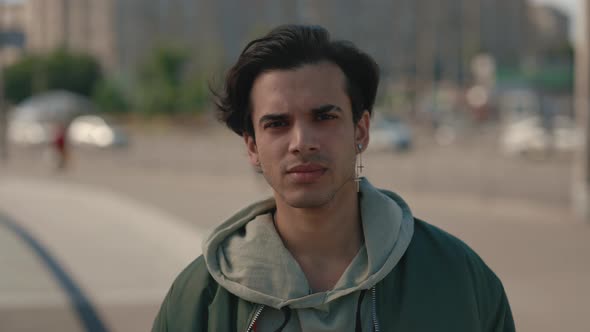 Portrait of Young Man with Calm Face Posing on City Street