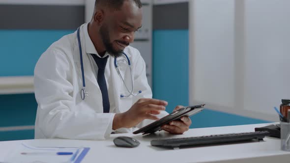 African American Therapist Doctor Holding Tablet Computer Checking Sickness Report