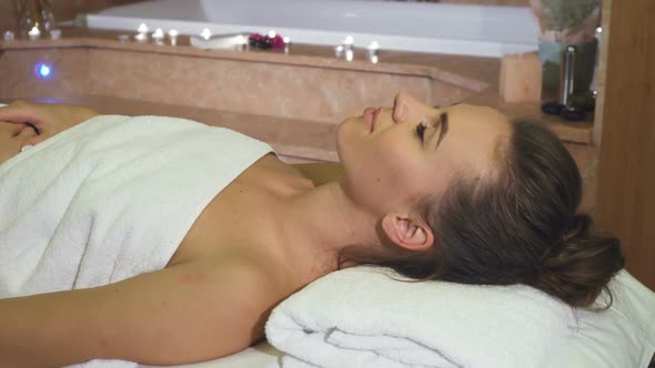 A Girl Enjoying Spa Treatments Looks Into the Camera and Smiles