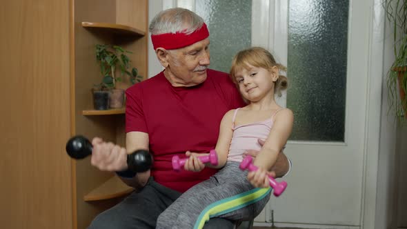 Active Grandfather Senior Man with Child Girl Doing Fitness Weight Lifting Exercises with Dumbbells