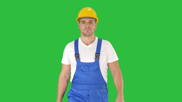 Walking worker in yellow helmet on a Green Screen, Chroma Key.