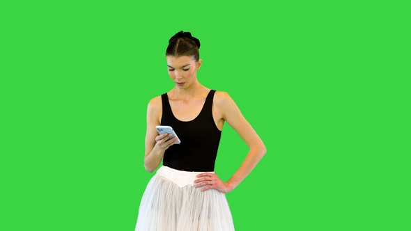 Tired Ballerina with Her Smartphone on the Break of Training on a Green Screen Chroma Key