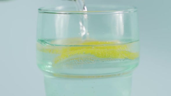 Putting natural mineral water into a glass.