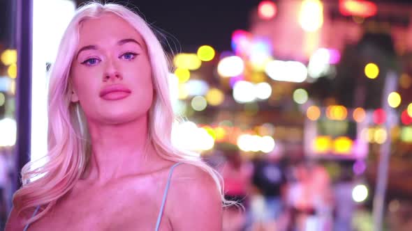 Portrait of Sexy Blonde Girl Night Out Posing To Camera in Colorful City