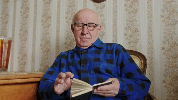 Senior Man with Glasses Flipping Through the Bible Medium Shot Indoor Seniority and Religion Concept