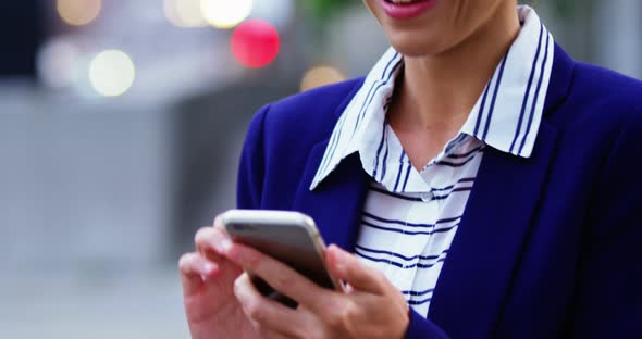 Businesswoman text messaging on mobile phone