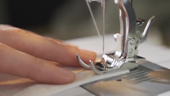 Seamstress Is Working Sewing Clothes in Sewing Machine Hands Closeup