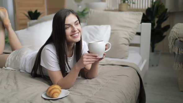 Young Woman Drinking Coffee in Bed