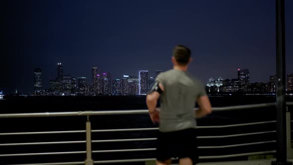 Side View of Young Male Sportsman with Athletic Body is Running with Effort and Dedication in City