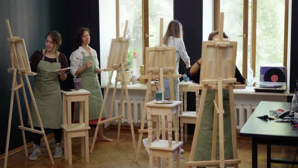 Four Female Students Painting at Art Lesson in Art Studio