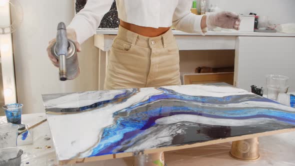 Using a Burner for a Painting Made of Blue Epoxy Resin