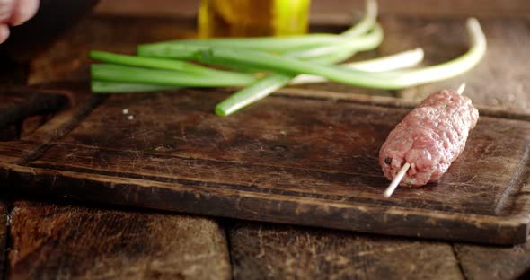 Men's Hands Put on the Table Raw Sausage Kebab.